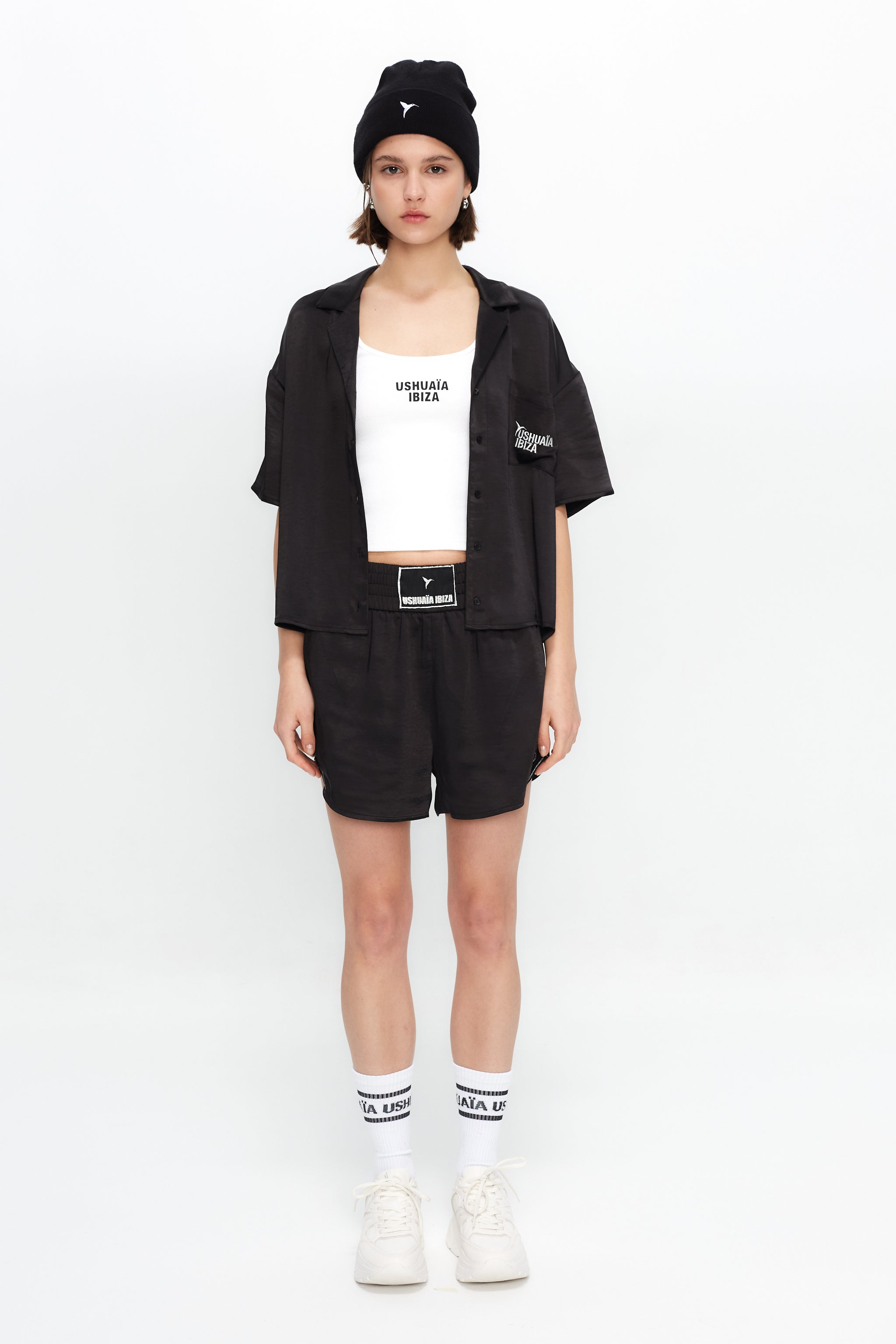 Cropped shirt with lapel collar made of satin fabric. Features an embroidery detail with lurex thread on the front pocket.