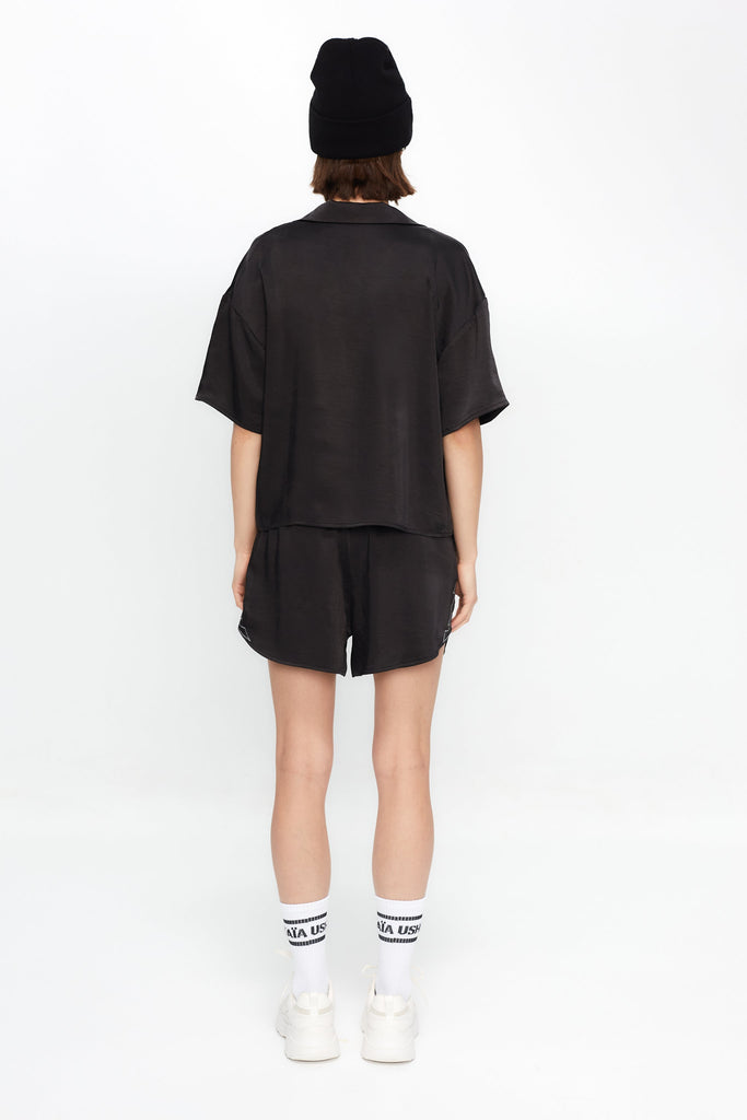 Cropped shirt with lapel collar made of satin fabric. Features an embroidery detail with lurex thread on the front pocket.