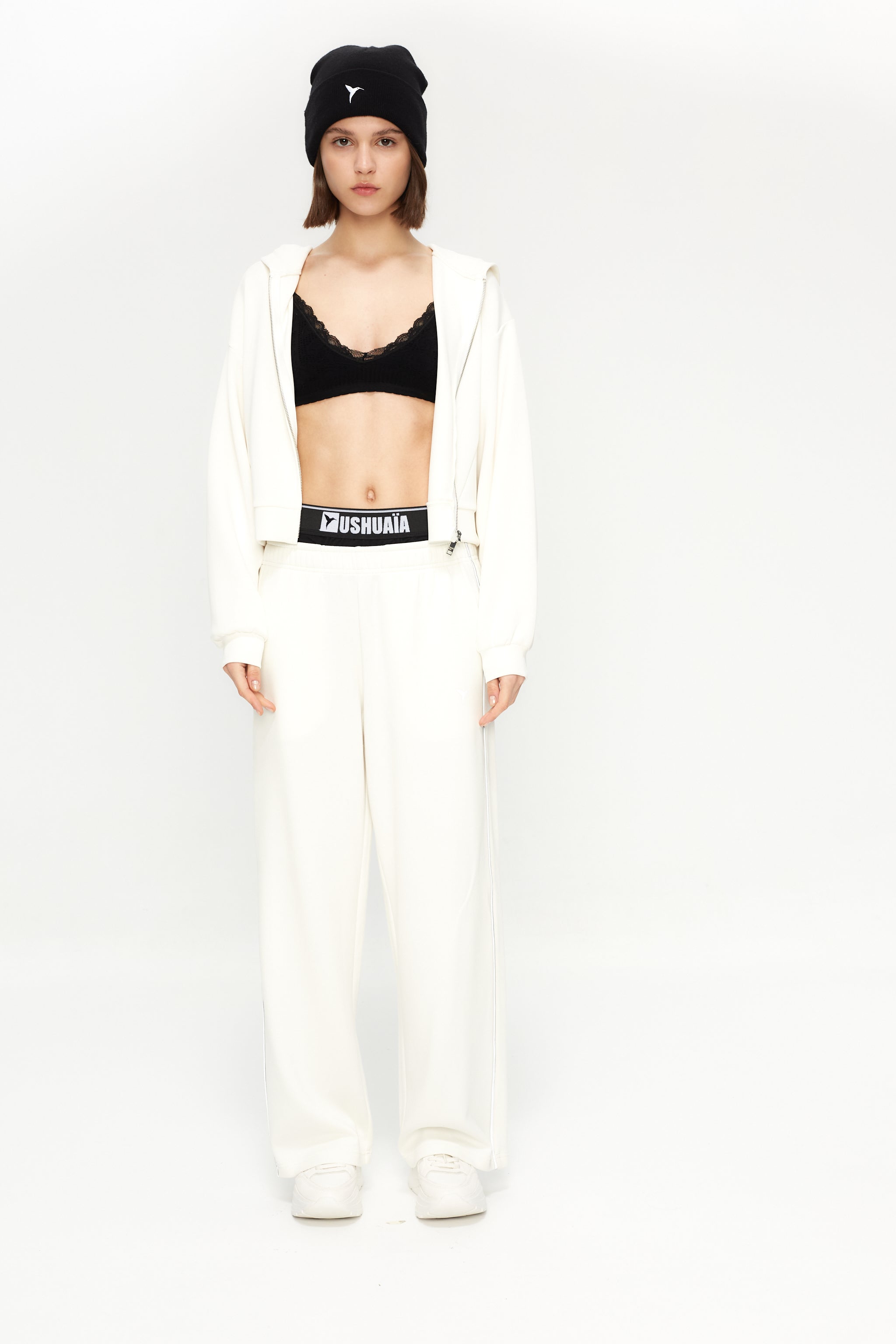 Cropped sweatshirt with hood and front closure. Features a reflective print on the back