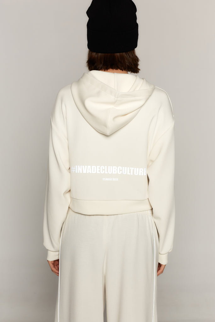 Cropped sweatshirt with hood and front closure. Features a reflective print on the back