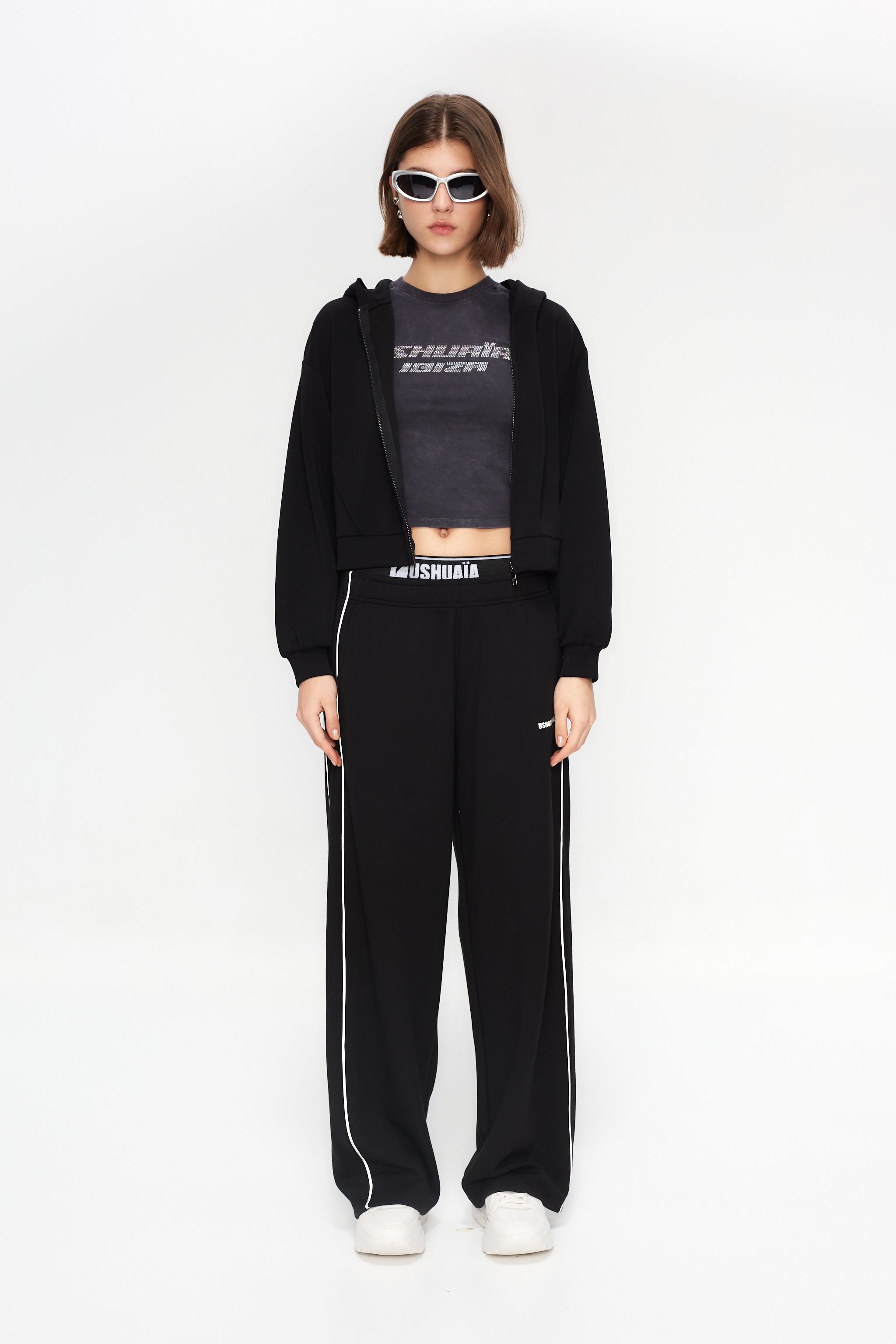 Cropped sweatshirt with hood and front closure. Features a reflective print detail on the back