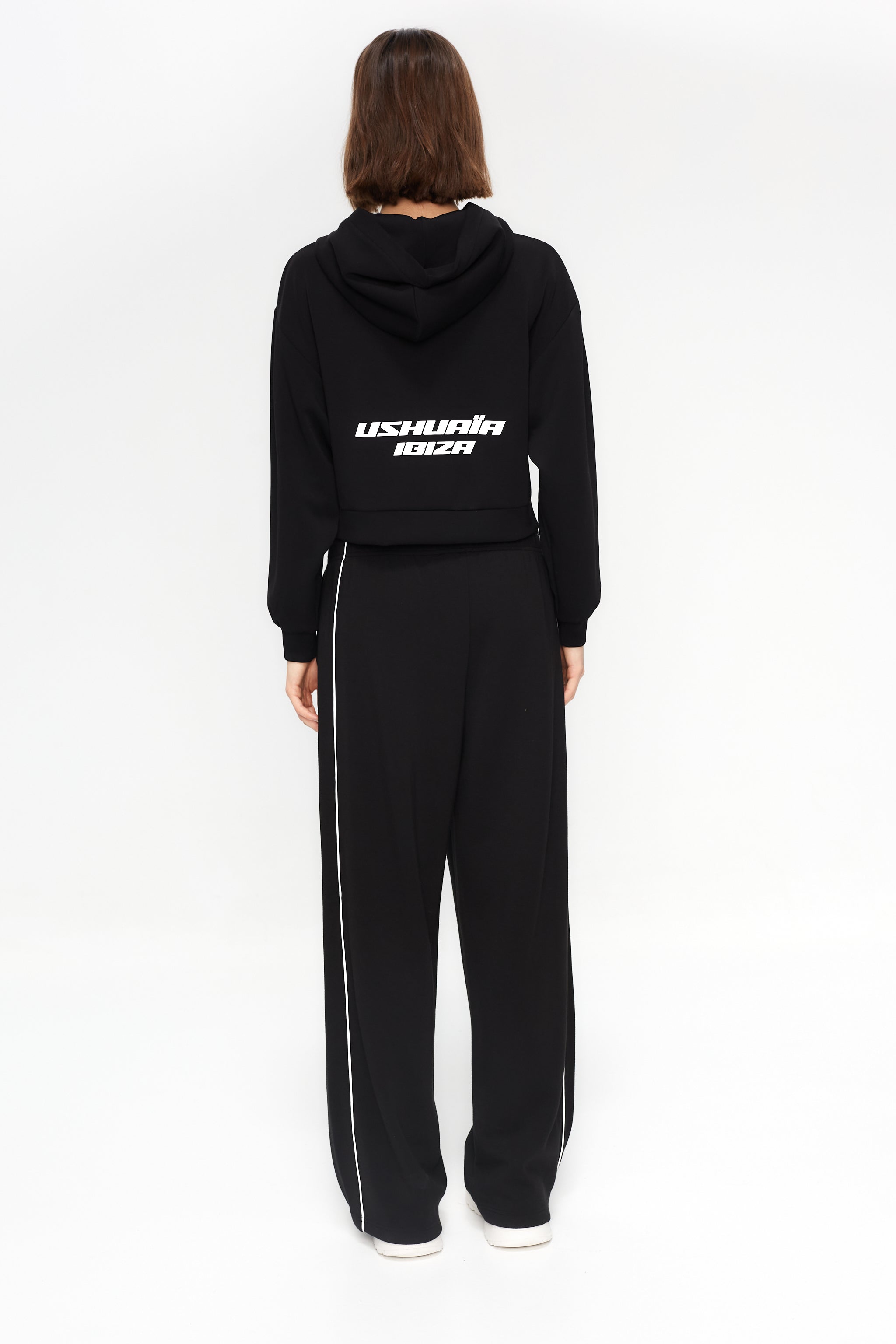 Cropped sweatshirt with hood and front closure. Features a reflective print detail on the back