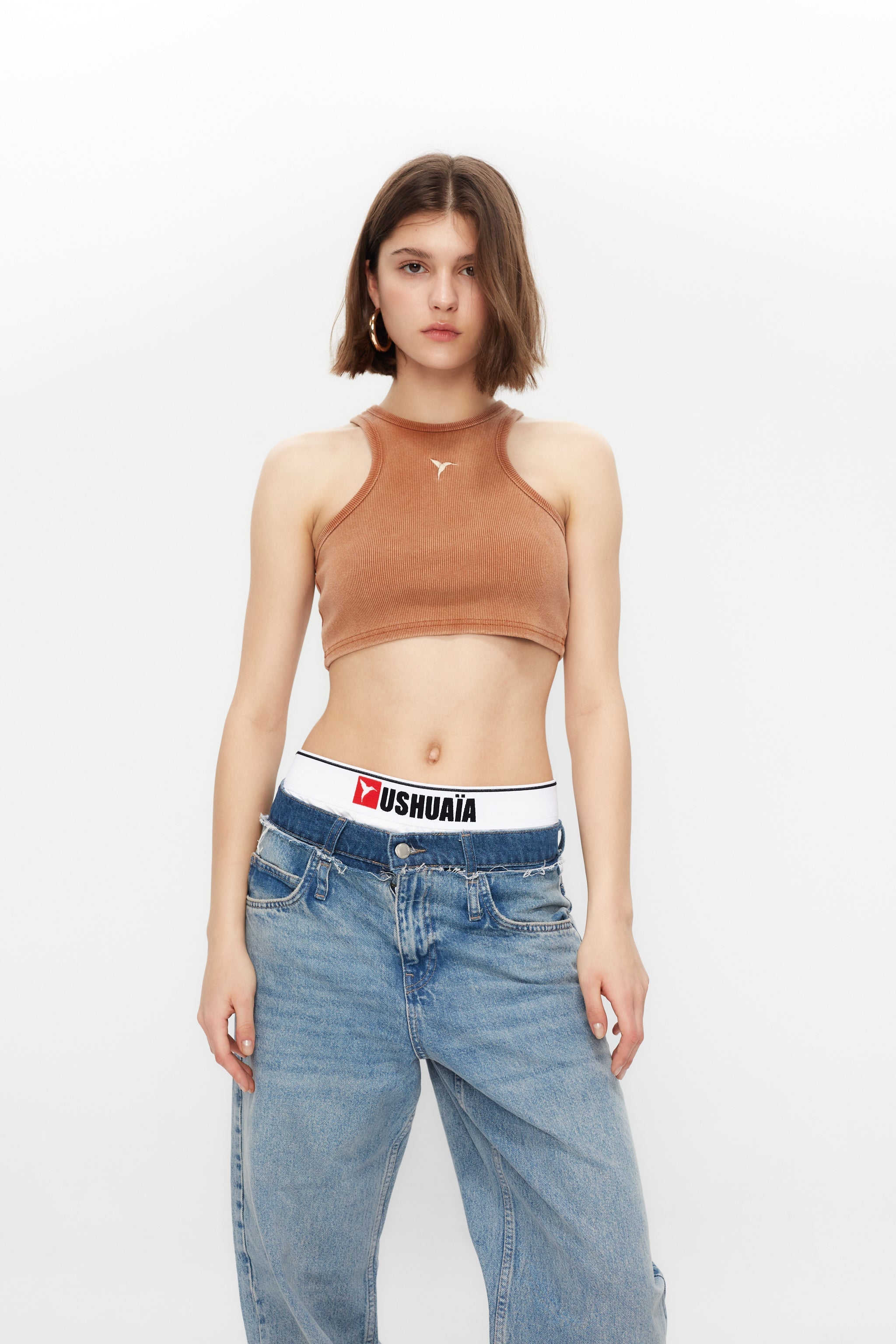 Rib tank top with round neckline and fade out effect sleeve. Embroidery detail on the front. 