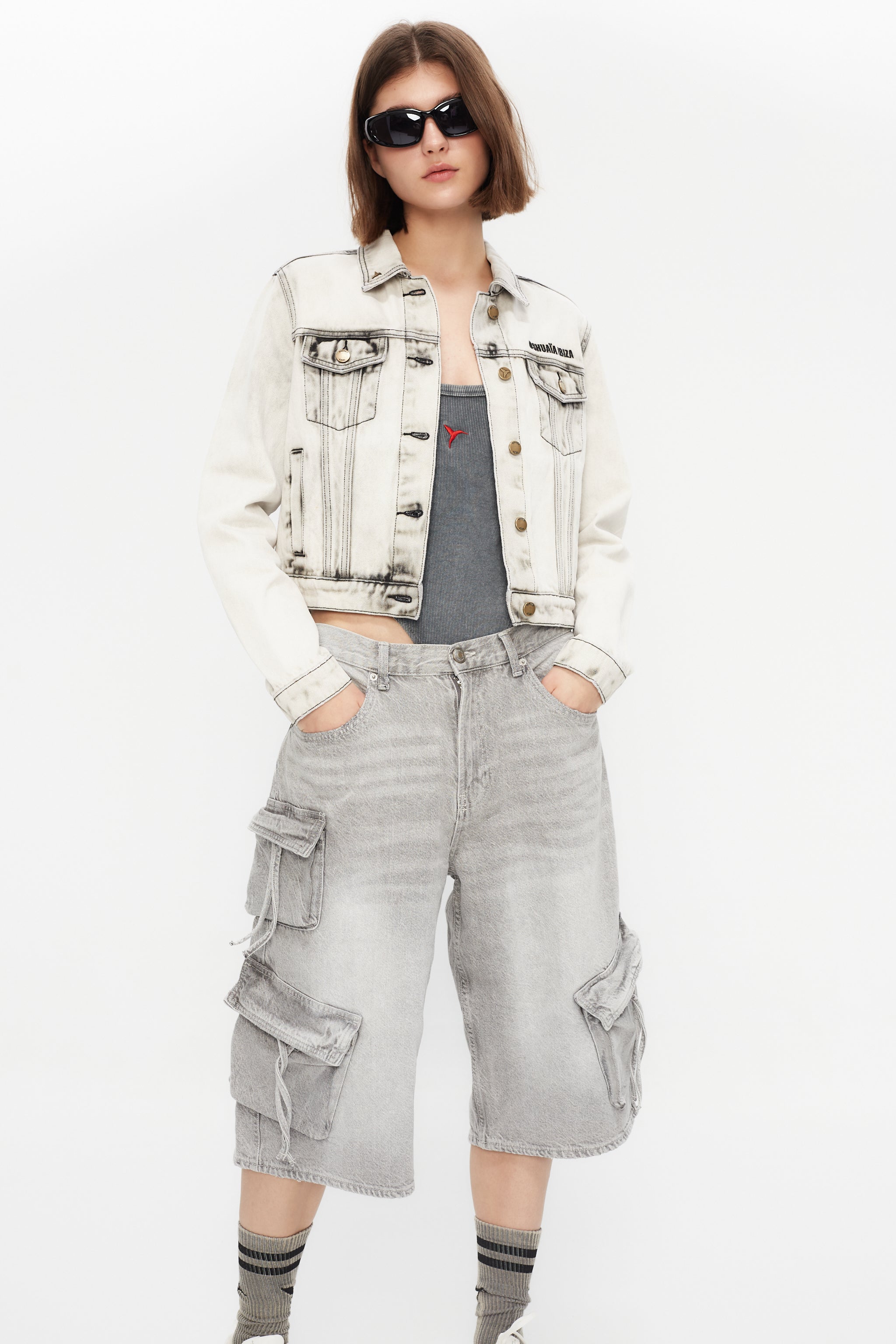 Cropped denim jacket with lapel collar and long sleeves, washed with a fade-out effect. Front closure with metal buttons. Features embroidery detail on the front and contrast combined print on the back. 