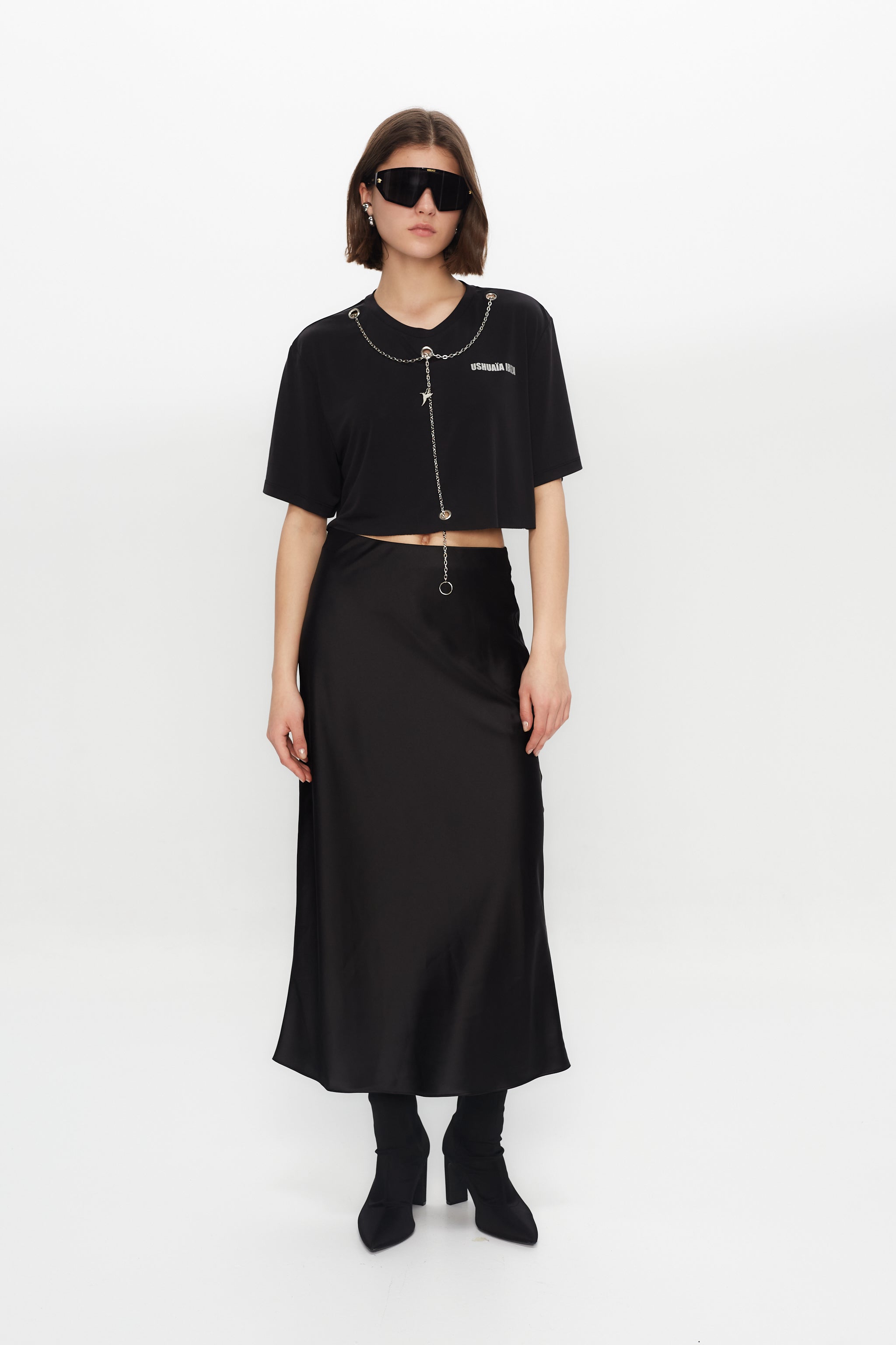 Black cropped T-shirt with metallic finish, bold front print & chain details. Perfect for edgy Ibiza vibes. Shop the trend now!