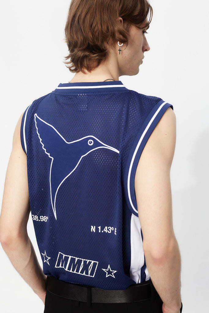 Basket shirt made of mesh fabric, lightweight and breathable. Round neck and ribbed armhole sleeves. Contrast combined print and application detail on front and back. Patch on the front.