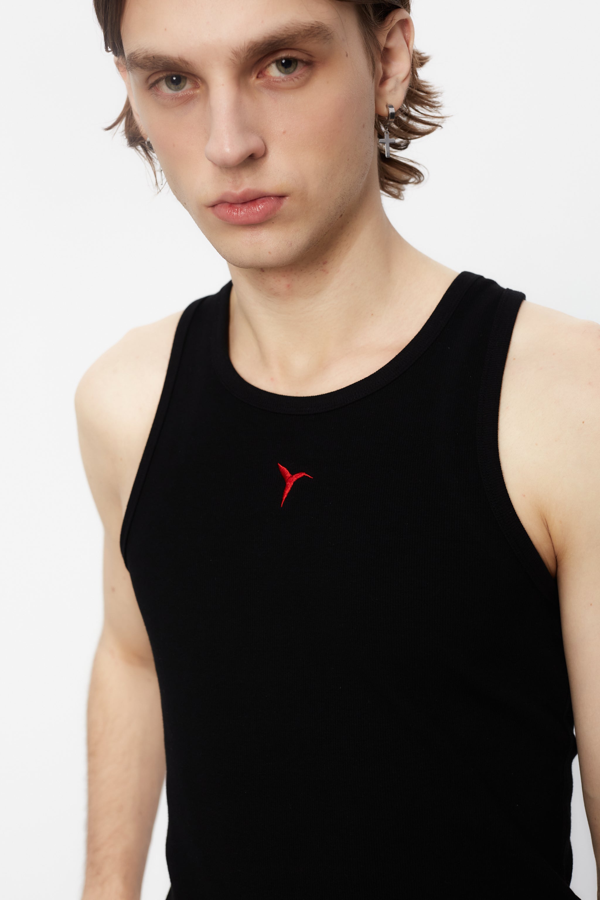 Ribbed t-shirt with a round neck and sleeveless design. Contrast embroidered detail on the front.