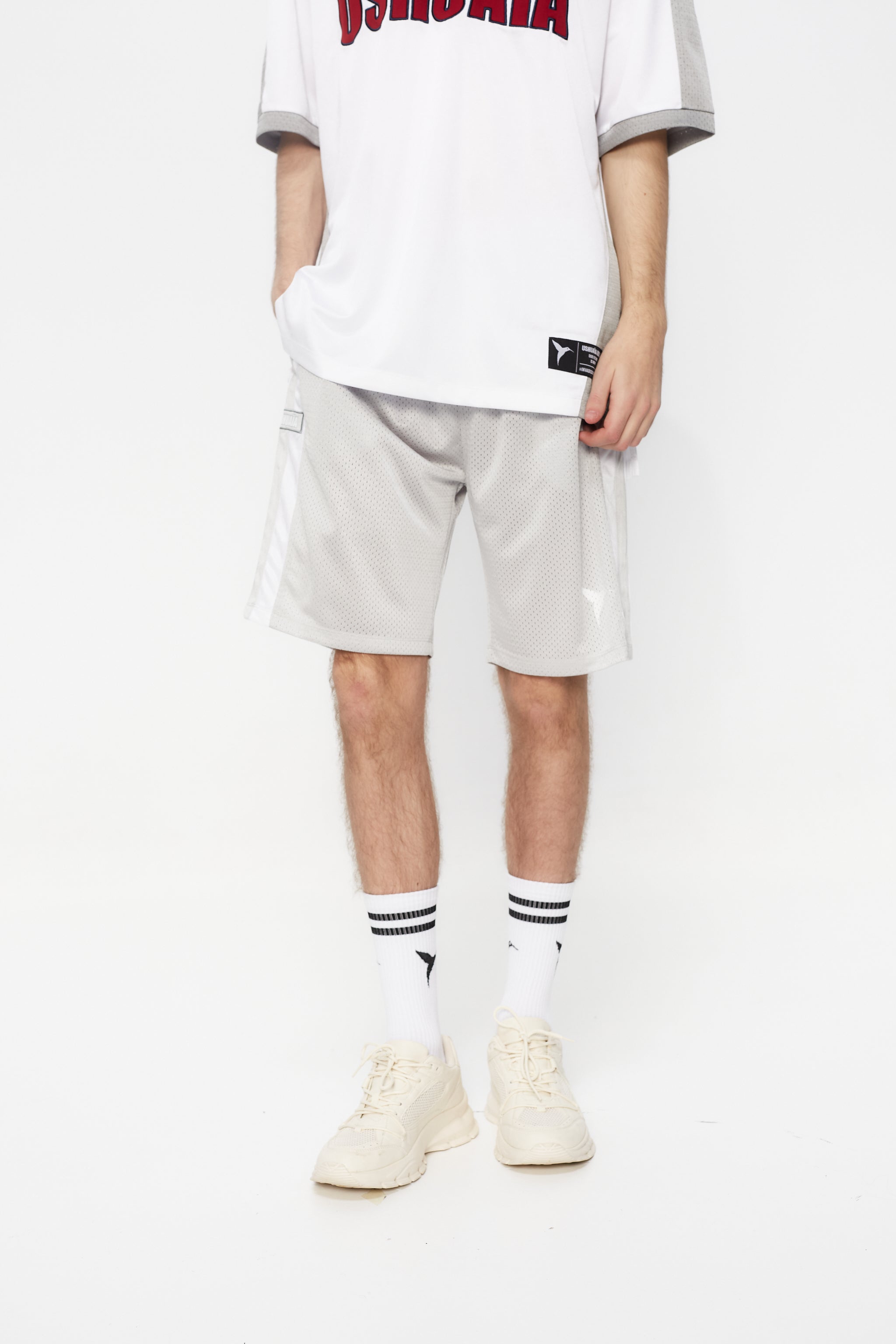 Bermuda shorts made of mesh fabric, light and breathable. Adjustable elastic waist with inner drawstring. Contrasting combined print on the front and side embroidery. Decorative snap detail on the sides with integrated pockets